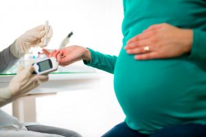 What is gestational diabetes? A pregnant woman with her hand over the bump